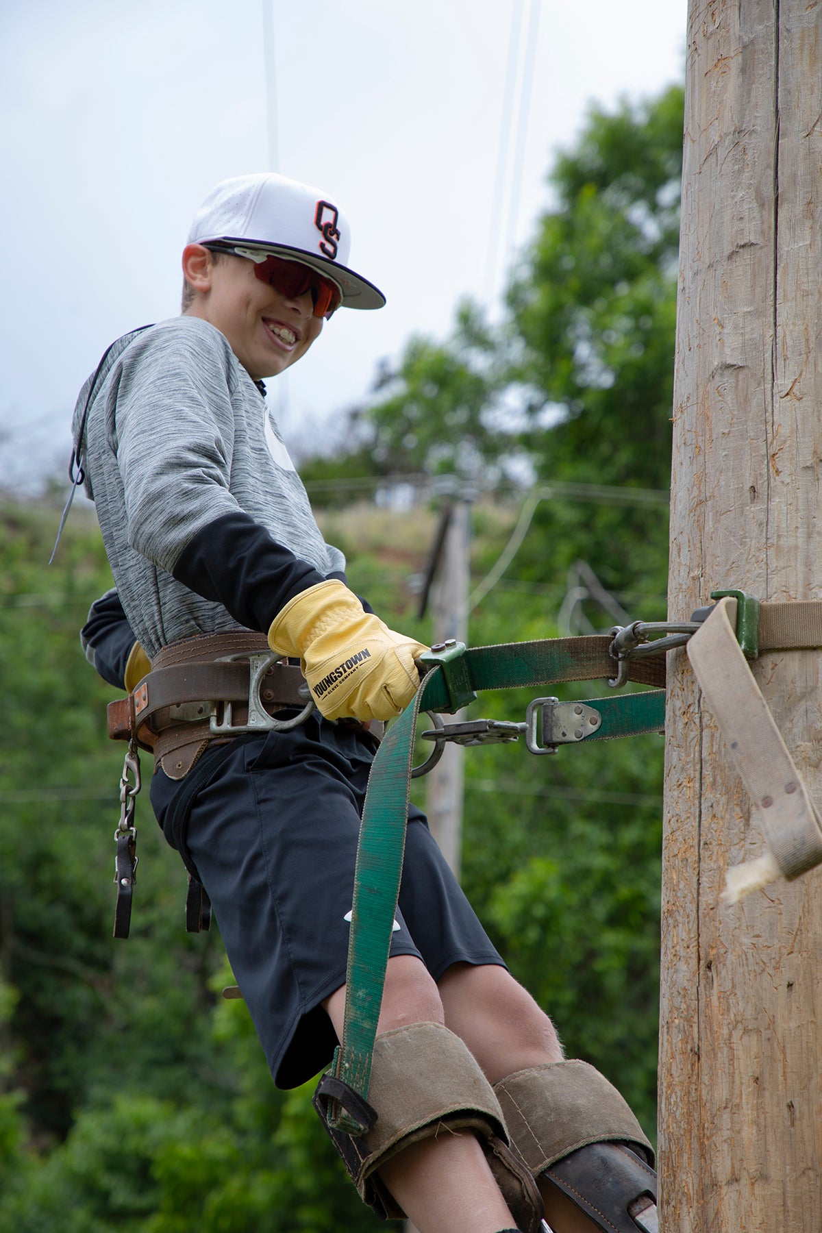 Energy Camp Participant Landon Helt climbing an electric pole.