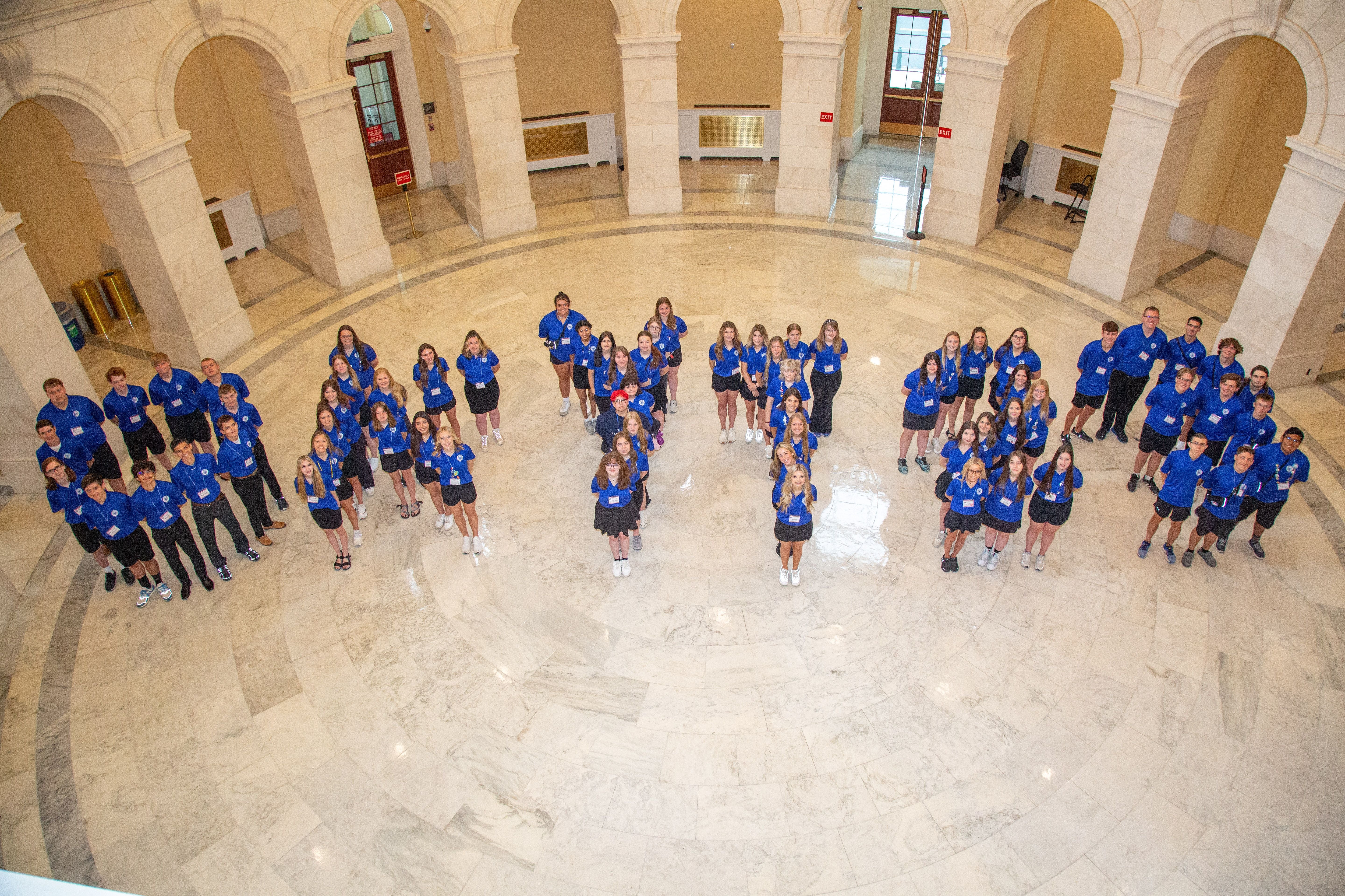 Participants shot from above spelling out OKYT23 in the gallery of the U.S. Capitol building..