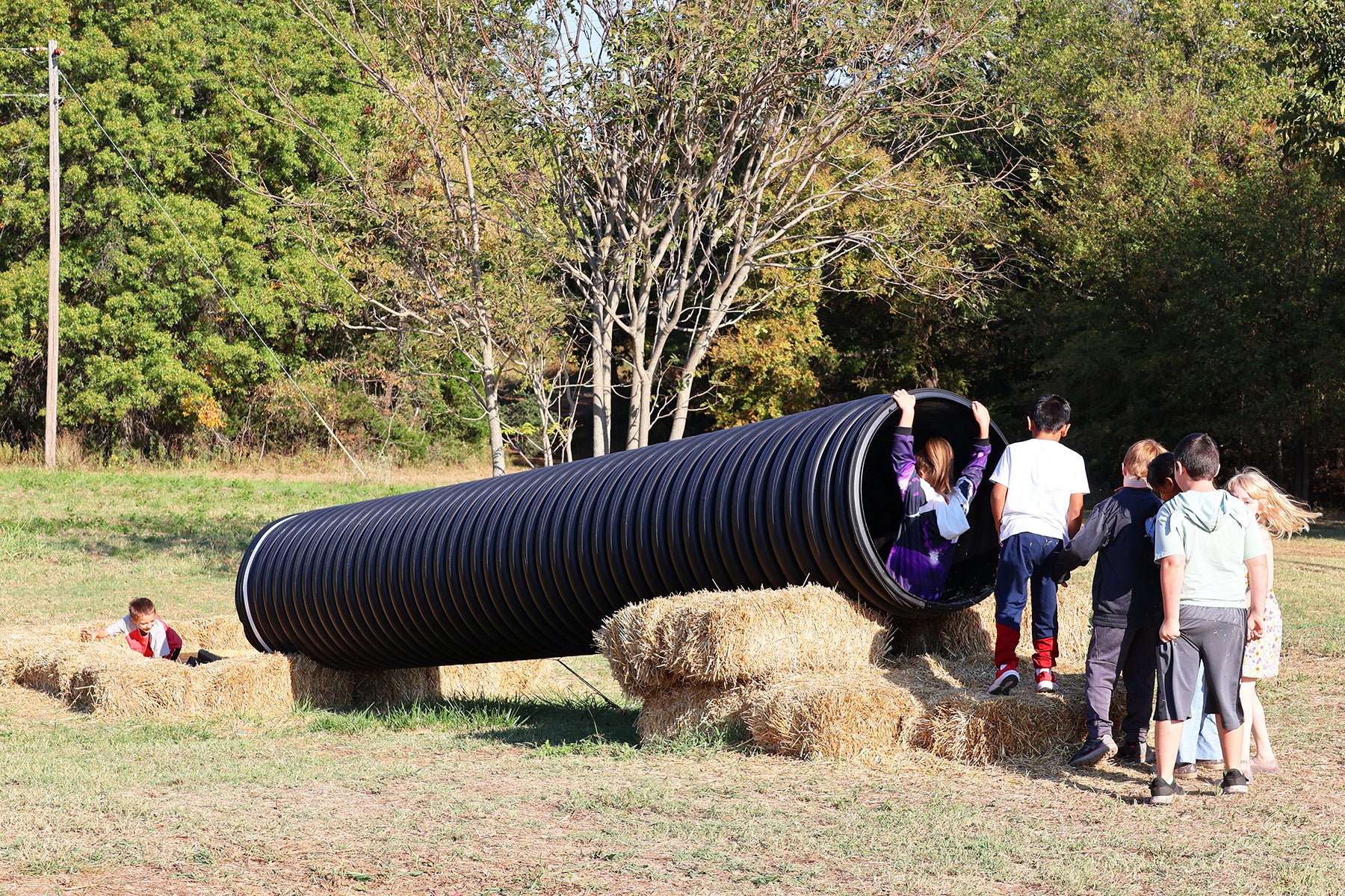 Kids playing in another slide made of a tube. 