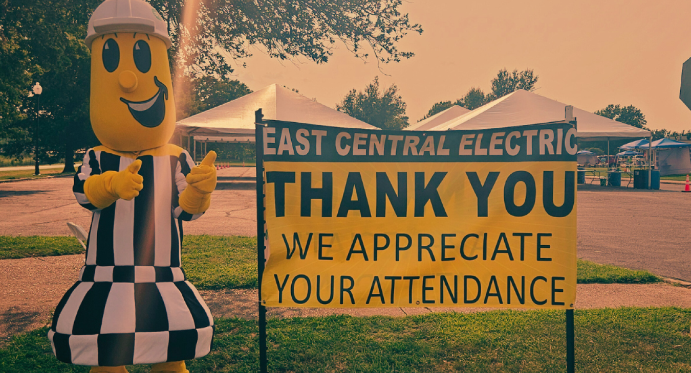 Image of Willie Wiredhand in front of a Thank You for Attending Sign.