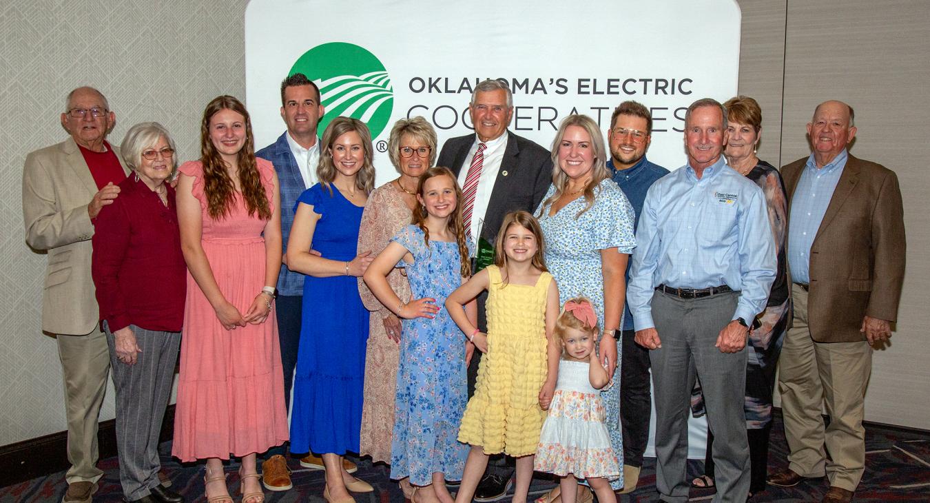 Tim Smith accepts the Hall of Fame Award with his family  and co-op board members during the OAEC 2024 Annual Meeting. 