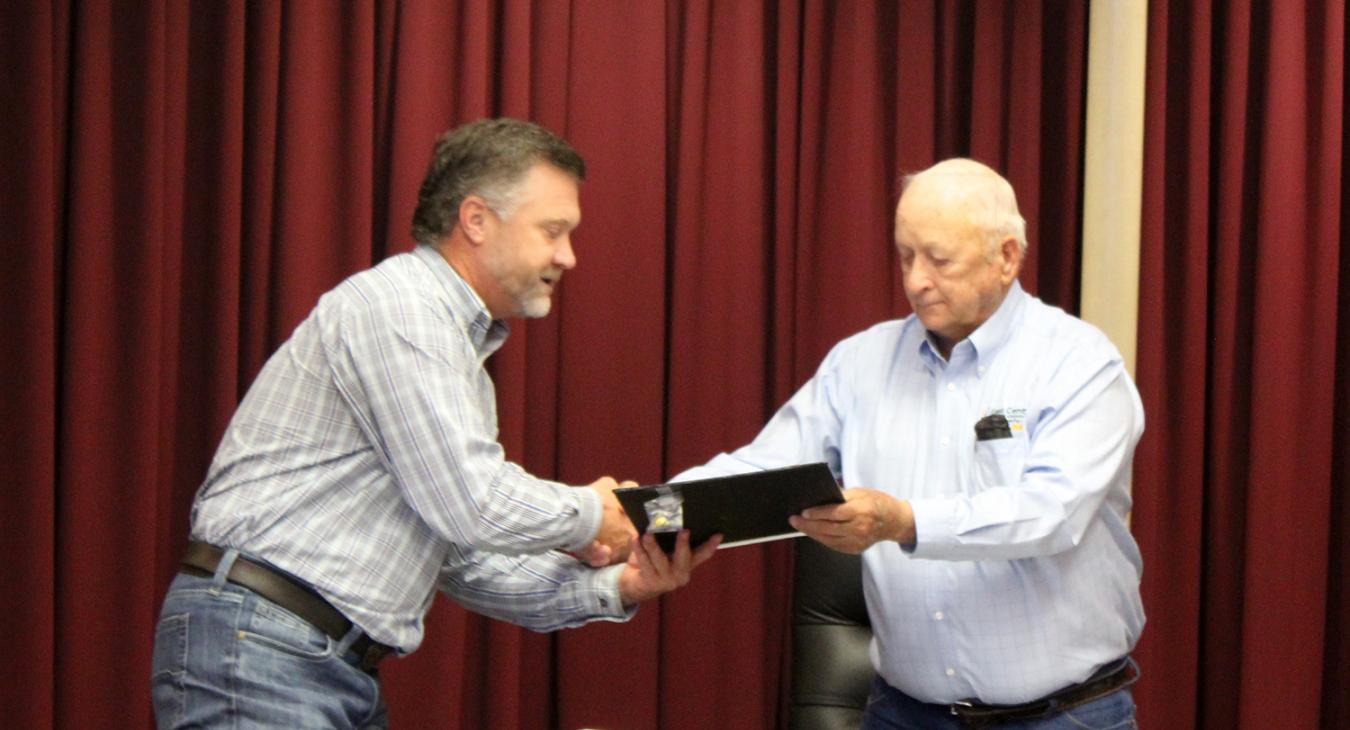 Jim Hall receiving award and handshake from Board President Lowell Hobbs