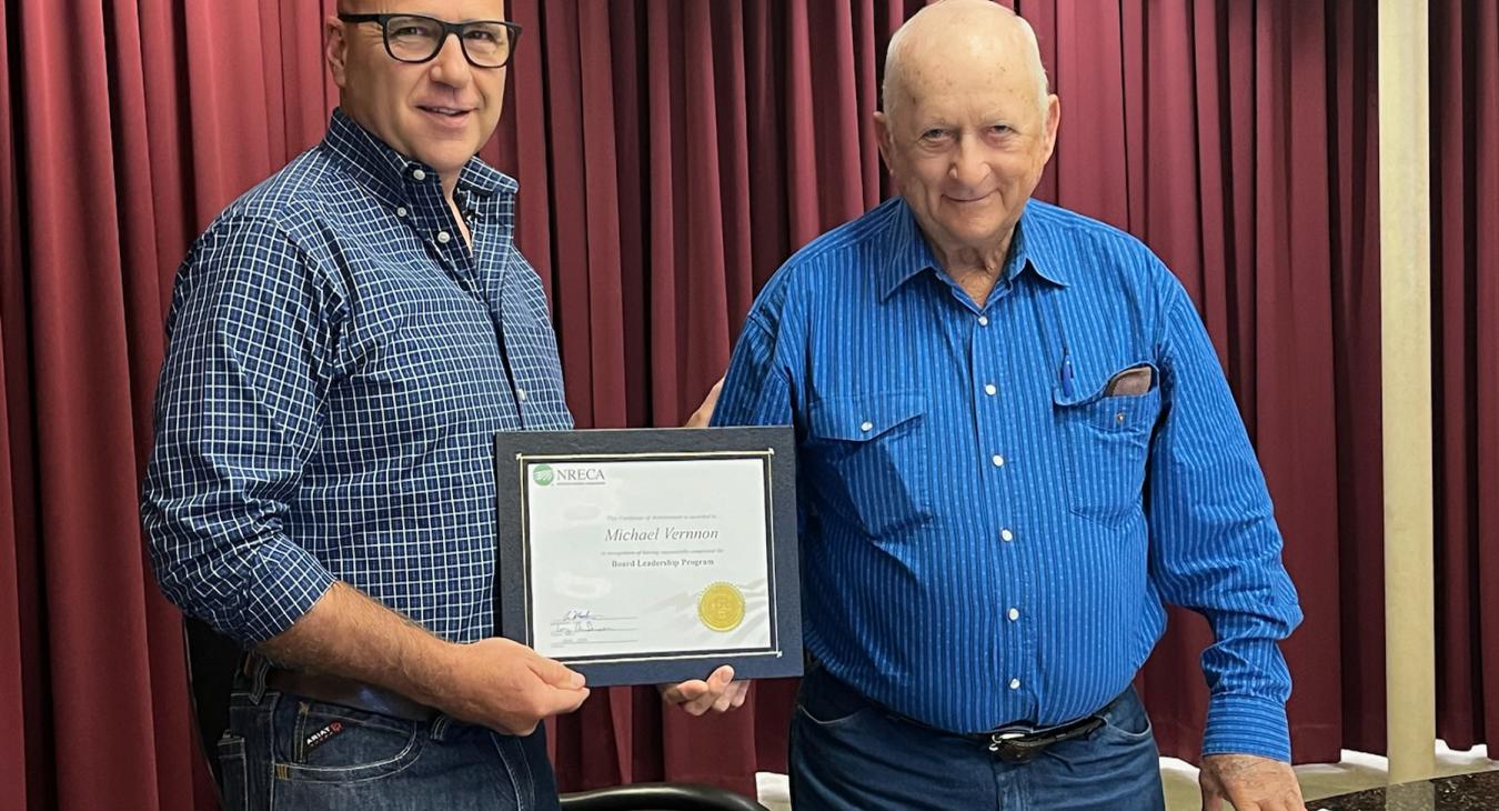 Trustee Mike Vernnon, left, accepts certificate from Board President Lowell Hobbs.